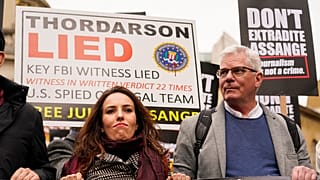 Julian Assange's partner Stella Morris, left, and Wikileaks editor-in-chief Kristin Hrafnsson hold placards and take part in a march in London, Saturday, Oct. 23, 2021