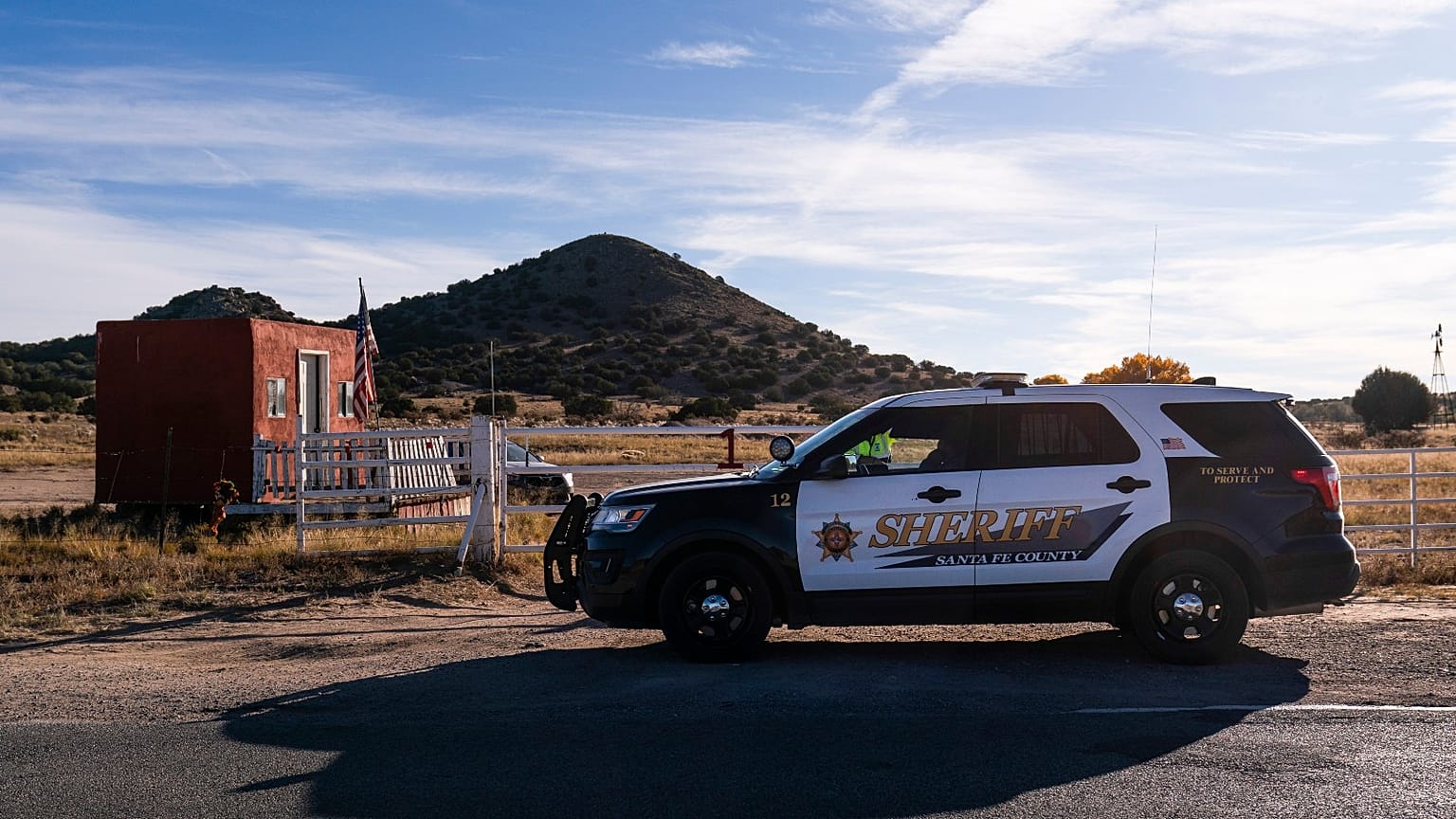 A Santa Fe County Sheriff's deputy briefly talks with a security guard at the entrance to the Bonanza Creek Ranch in Santa Fe, N.M., Monday, Oct. 25, 2021.