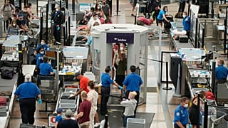 Travellers wear face coverings in the line for the south security checkpoint in the main terminal of Denver International Airport on Aug. 24, 2021, in Denver. 