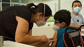 Un trabajador sanitario inyecta a un niño una dosis de la vacuna COVID-19 de Pfizer, 20/10/2021, Tuxtla Gutierrez. México