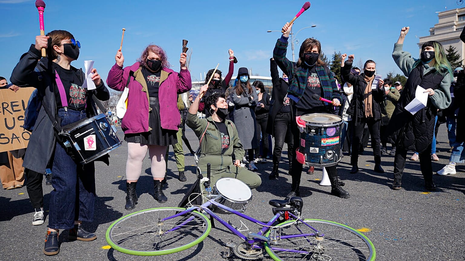 FILE: Women take part in rally during International Women's Day outside the government headquarters in Bucharest, Romania, Monday, March 8, 2021