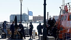 مهاجرون ينزلون من سفينة تابعة لخفر السواحل بعد عملية في جزيرة خيوس شمال شرق بحر إيجة في اليونان.
