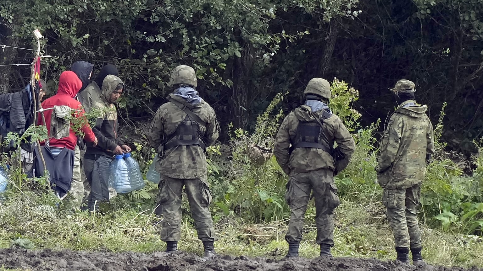 Migránsok, lengyel határőrök a belarusz-lengyel határon