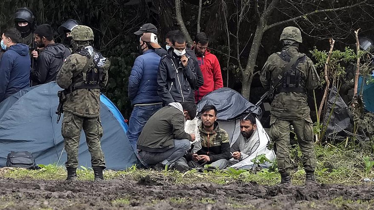  مهاجرون جالسون بعد عبور الحدود من بيلاروس إلى بولندا،  في قرية أوسنارز غورني ، بولندا. 1 سبتمبر 2021 