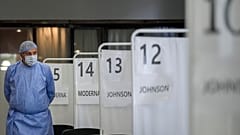 A medical staff member walks by vaccination booths in Bucharest, Romania, Oct. 22, 2021.