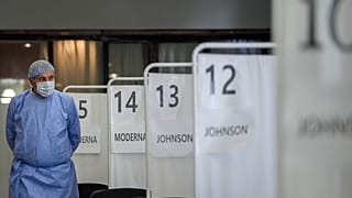 A medical staff member walks by vaccination booths in Bucharest, Romania, Oct. 22, 2021.