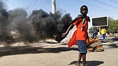 Un très jeune Soudanais drapé dans son drapeau national à Khartoum, mardi 26 octobre 2021