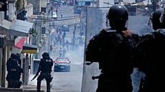 La policía observa a los manifestantes retirarse, en Quito, tras lanzarles gases lacrimógenos, en el segundo día de protestas en Ecuador. 