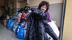 Krystyna Luczewska carries a winter coat as she came to give warm clothes to migrants at the help center in Michalowo Poland, on October 22, 2021.