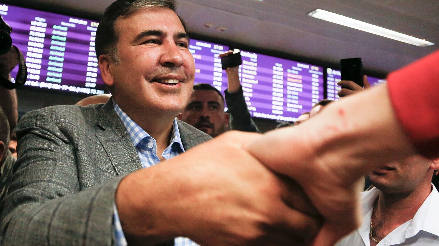 Georgia's former President Mikheil Saakashvili greets supporters upon arrival at Boryspil Airport, outside Kyiv, Ukraine, May 29, 2019.
