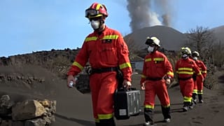 UME officers walking with volcano behind