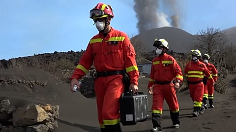 UME officers walking with volcano behind