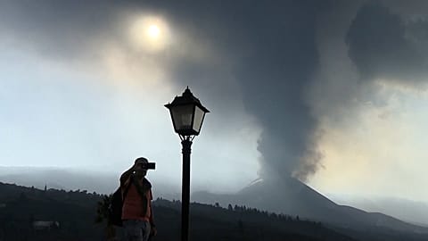 Tourist filming the volcano with his mobile phone