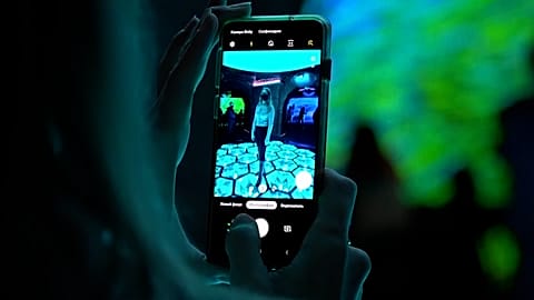 A visitor takes a photo inside a new exhibition entitled 'Digital Twins' in the Zifergauz gallery in St Petersburg, Russia. 