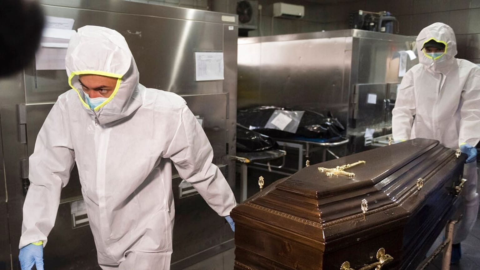 Funeral house employees remove a coffin with a COVID-19 victim 