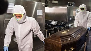Funeral house employees remove a coffin with a COVID-19 victim 