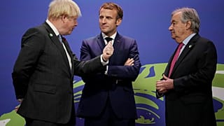 Britain's PM Boris Johnson (L) and UN Secretary General Antonio Guterres (R) greet French President Emmanuel Macron (C) as he arrives to attend the COP26 in Glasgow. 