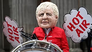 A masked Oxfam protester dresses up as Boris Johnson ahead of the World Leaders Summit at COP26