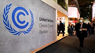A woman walks by a sign inside the COP26 UN Climate Summit in Glasgow, Scotland, Tuesday, Nov. 2, 2021. 