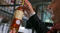 An unidentified auction goer displays a bottle of 1966 Chateau d'Yquem premier cru Sauternes put on auction by the French presidential Palace. File: May 2013