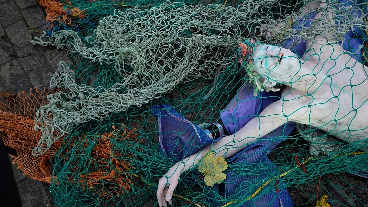 A protester dressed as a dead merepeole attends a demonstration against bottom fishing by Extinction Rebellion.