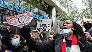 Manifestantes sostienen pancartas en una protesta contra el cambio climático frente al Standard and Chartered Bank en Londres, Reino Unido, el 29 de octubre de 2021. 