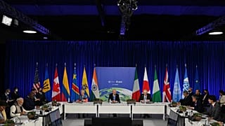 US President Joe Biden (C), flanked by President of the European Commission Ursula von der Leyen (L) and British Prime Minister Boris Johnson (R), speaks  at COP26.