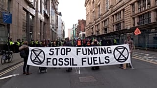Extinction Rebellion protesters holding banner outside of JP Morgan