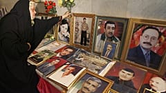 Une femme irakienne dépose des fleurs à côté de photos encadrées de journalistes irakiens tués en Irak en 2007.
