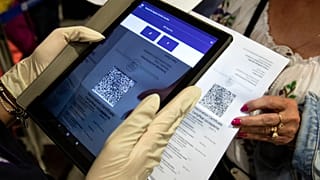 A Greek police officer scanning the EU Digital COVID Certificate