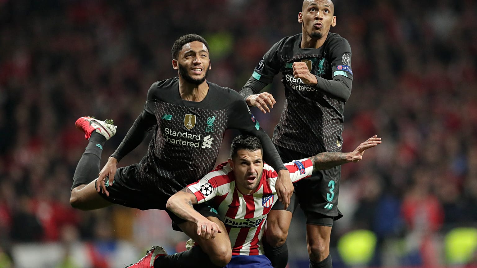 Liverpool's Fabinho, right, and Joe Gomez jump for a header with Atletico Madrid's Vitolo