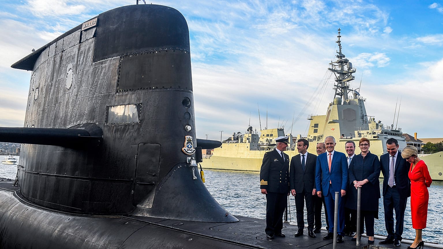 FILE: French President Emmanuel Macron, second left, and Australian Prime Minister Malcolm Turnbull, centre, stand on the submarine HMAS Waller in Sydney.