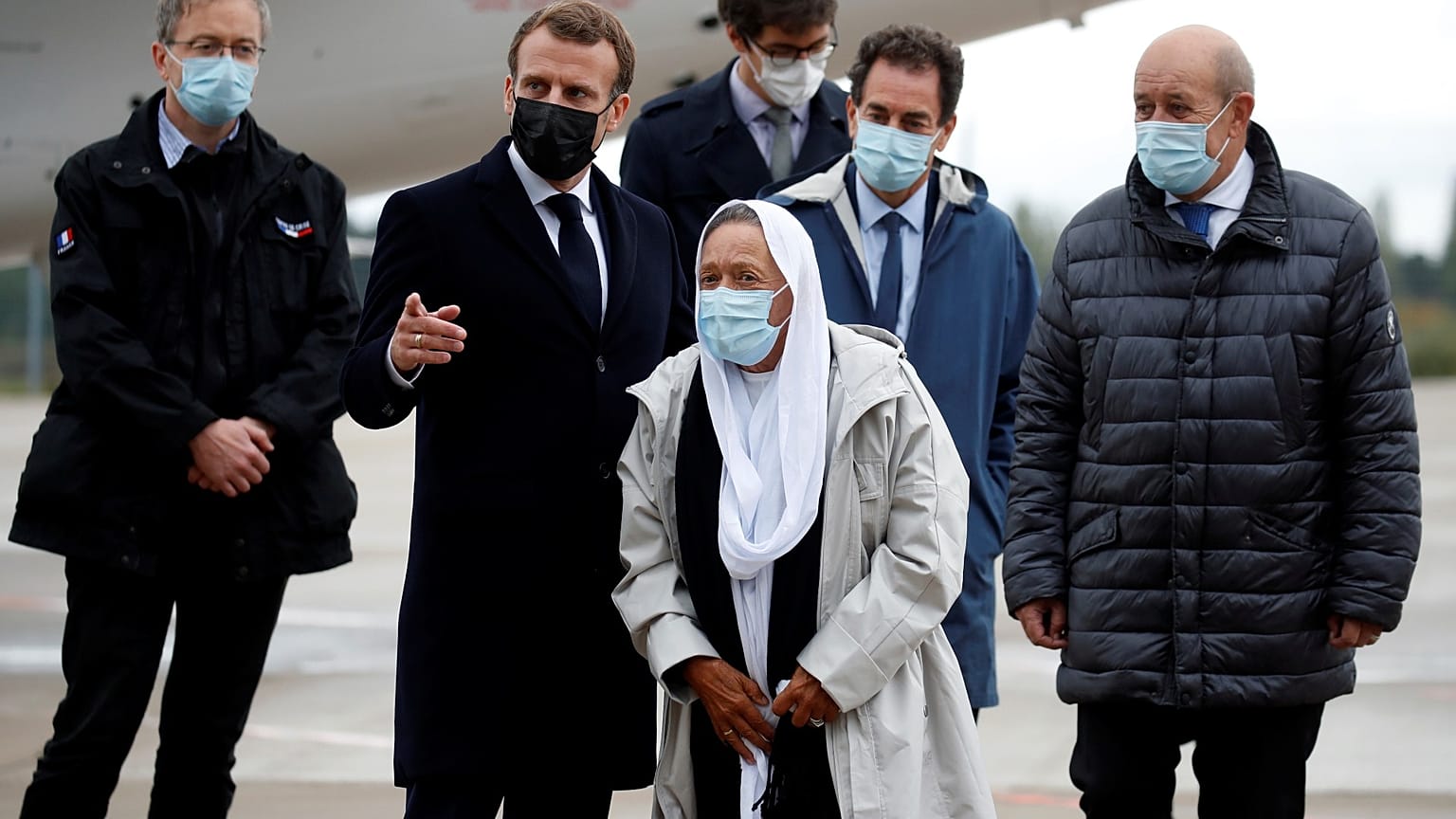 France's President Emmanuel Macron, centre left, and Foreign Minister Jean-Yves Le Drian (R), welcome Sophie Petronin, centre, near Paris, Oct. 9, 2020. 