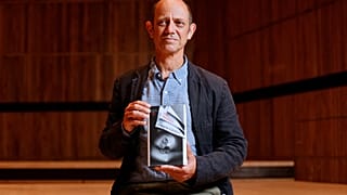 South African author Damon Galgut poses with his book 'The Promise' shortlisted for the 2021 Booker Prize for Fiction in London on October 31, 2021.