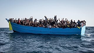 Barco de madeira sobrelotado de migrantes auxiliado no Mediterrâneo
