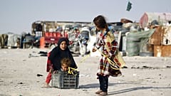 أطفال عائلة عراقية فقيرة تعيش في مبانٍ مصنوعة من الخردة المعدنية، يلعبون خارج منازلهم في مدينة النجف، العراق، 6 فبراير / شباط 2016.