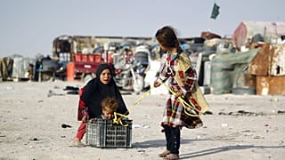 أطفال عائلة عراقية فقيرة تعيش في مبانٍ مصنوعة من الخردة المعدنية، يلعبون خارج منازلهم في مدينة النجف، العراق، 6 فبراير / شباط 2016.