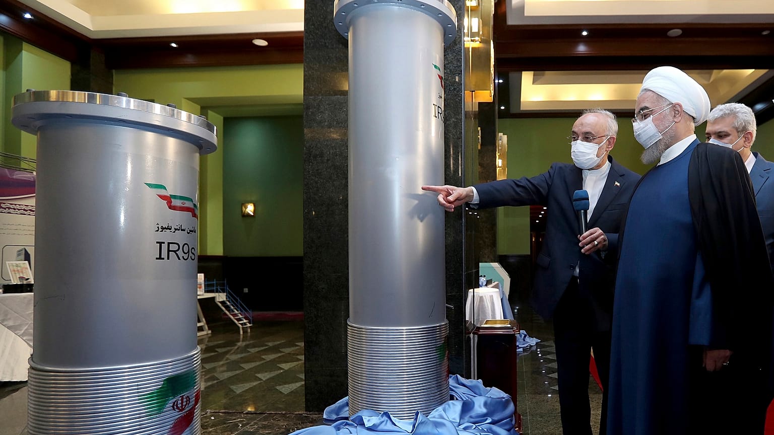 President Hassan Rouhani (R) listens to head of the Atomic Energy Organization while visiting an exhibition of Iran's new nuclear achievements in Tehran on April 10, 2021. 