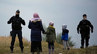 Police officers patrol near a migrant camp in Calais, northern France