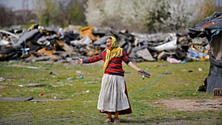 A woman scraping a living from burning scrap metal gestures during a raid by the National Environmental Guard in Vidra, Romania in April 2021