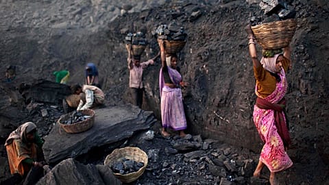 People carry baskets of coal scavenged illegally at an open-cast mine in the village of Bokapahari in the eastern Indian state of Jharkhand.