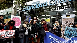 Gli attivisti per il clima, tra cui Dominique Palmer, manifestano, davanti alla sede della banca Standard Chartered a Londra (29 ottobre 2021)
