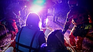 Rescuers from Bosnia's mountain rescue services drag a boat with people evacuated from their homes in the village of Ahatovići, near Sarajevo
