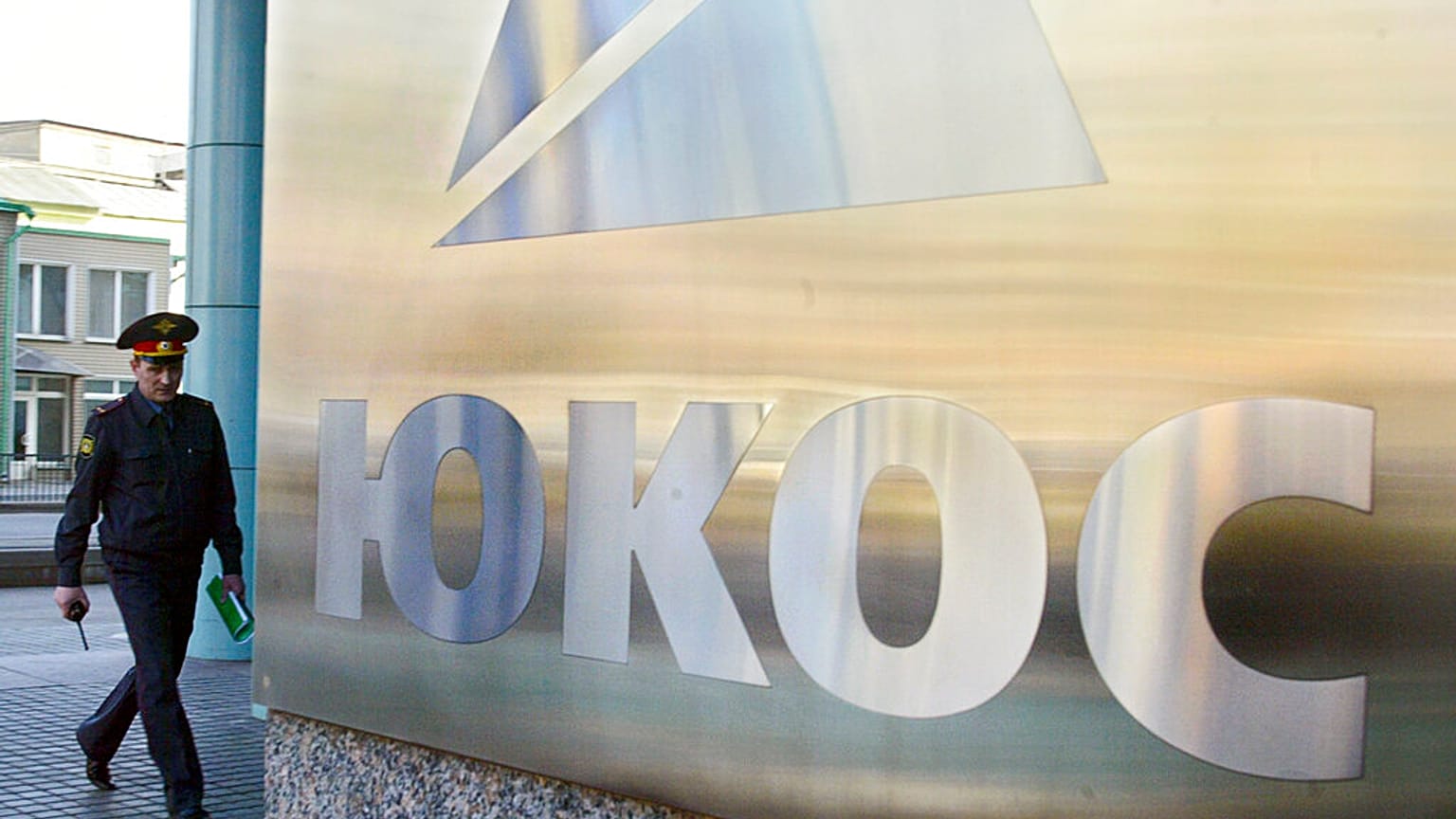A police officer patrols near the headquarters of the bankrupt oil giant OAO Yukos during an auction of shares in Rosneft that had been owned by Yukos, Moscow, Tuesday March 2