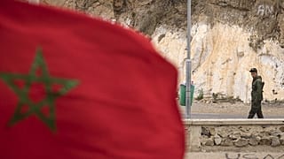 A picture taken from the Moroccan region of Oujda shows an Algerian border guard patrolling along the border with Morocco on November 4, 2021.