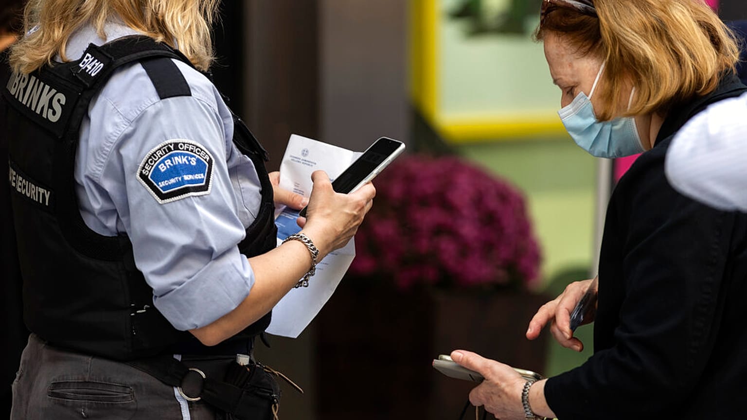 A woman is checked for her Covid-19 vaccination certificate in order to be allowed to enter a shop in Athens, Greece