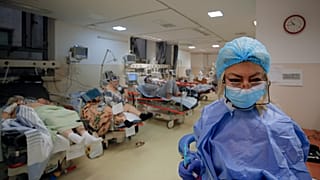 Patients lie on beds in a crowded COVID-19 isolation room at the University Emergency Hospital in Bucharest, Romania, Friday, Oct. 22, 2021.