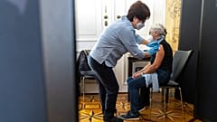 A patient is vaccinated against the COVID-19 virus on the national holiday in the Vienna Imperial Palace in the marble hall in Vienna, Austria, Tuesday, Oct. 26, 2021.