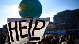 A banner held aloft at climate protests in Lausanne, Switzerland on Saturday 