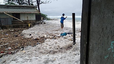 This photo taken on March 3, 2014 shows a resident surrounded by the on-rushing high tide energized by a storm surge that damaged a number of homes across Majuro.